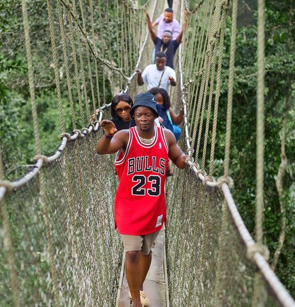 a group of people walking across a suspension bridge